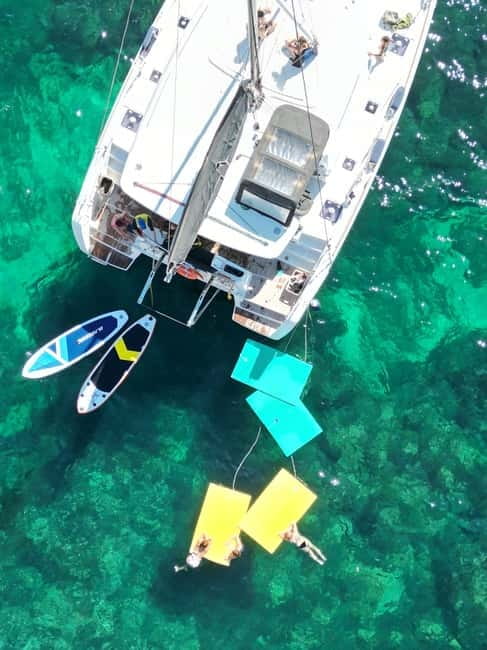 Majorca: Dinner aboard a private catamaran with snorkeling and paddle surfing - Sunset dinner on board: seafood, local flavors, and city lights later